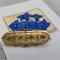 guldfarvet-metal-oval-broche-fin-forarbejdet-kant-ciceleret-mønster-vintagebroche